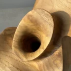 Close-up of flowing carved surfaces and natural colour transitions in walnut wood.