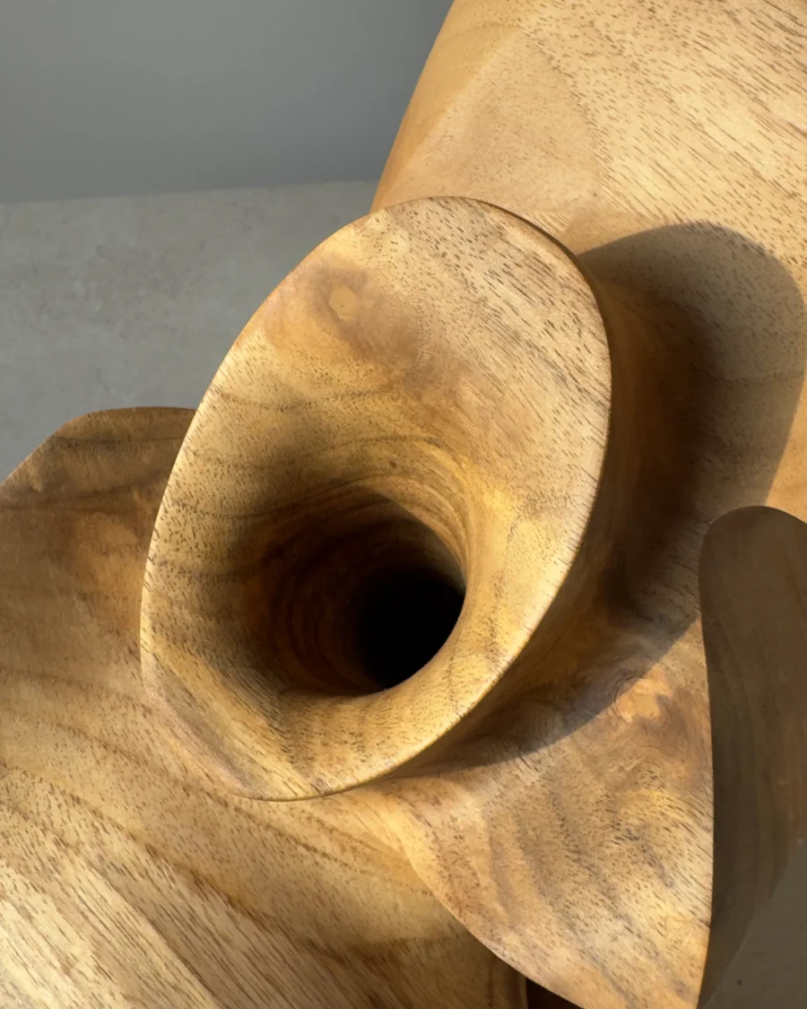Close-up of flowing carved surfaces and natural colour transitions in walnut wood.