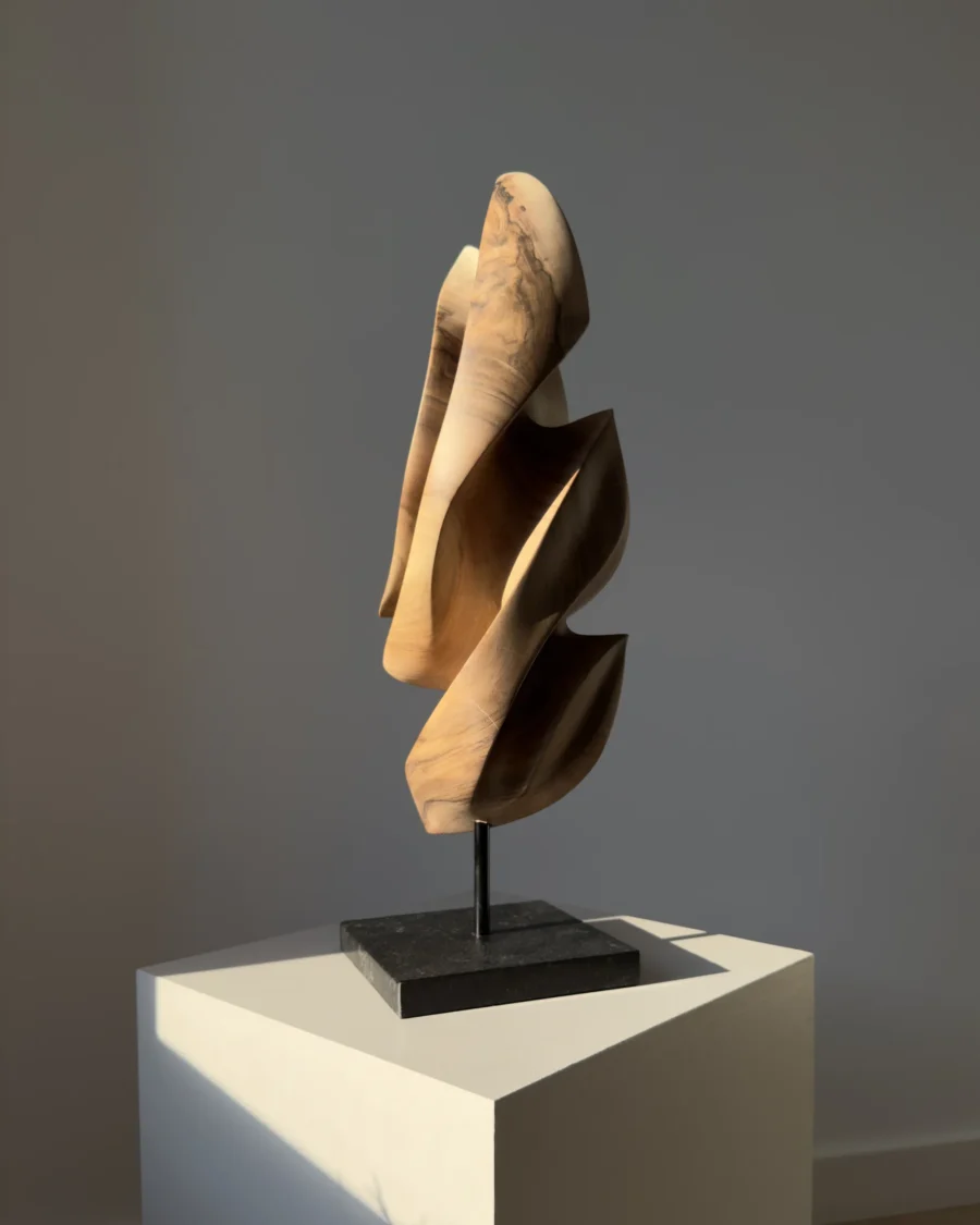 Perspective view of Silent Ascent hand-carved walnut wood sculpture highlighting its flowing vertical form.