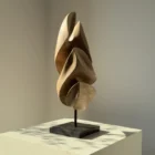 Light and shadow revealing the sculptural curves of Silent Ascent hand-carved walnut sculpture.