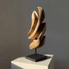 Profile view of Silent Ascent contemporary walnut sculpture showing organic curves and changing light.