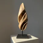 Detail of the polished black granite base supporting the Silent Ascent walnut sculpture.