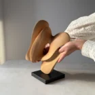 Hand-carved apple wood sculpture "Sway" shown in scale, mounted on a black granite base, rear view.