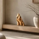 Together as One hand-carved walnut wood sculpture displayed on a wooden console in a calm Japandi interior with natural light.