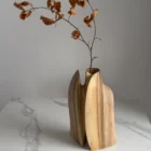 Twin Presence sculptural walnut vase displayed in natural light within a contemporary interior.
