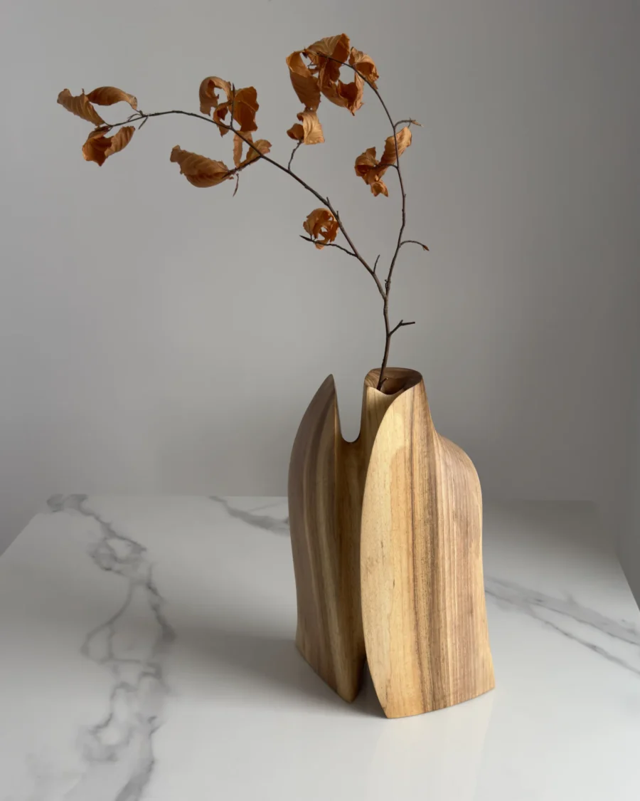 Twin Presence sculptural walnut vase displayed in natural light within a contemporary interior.