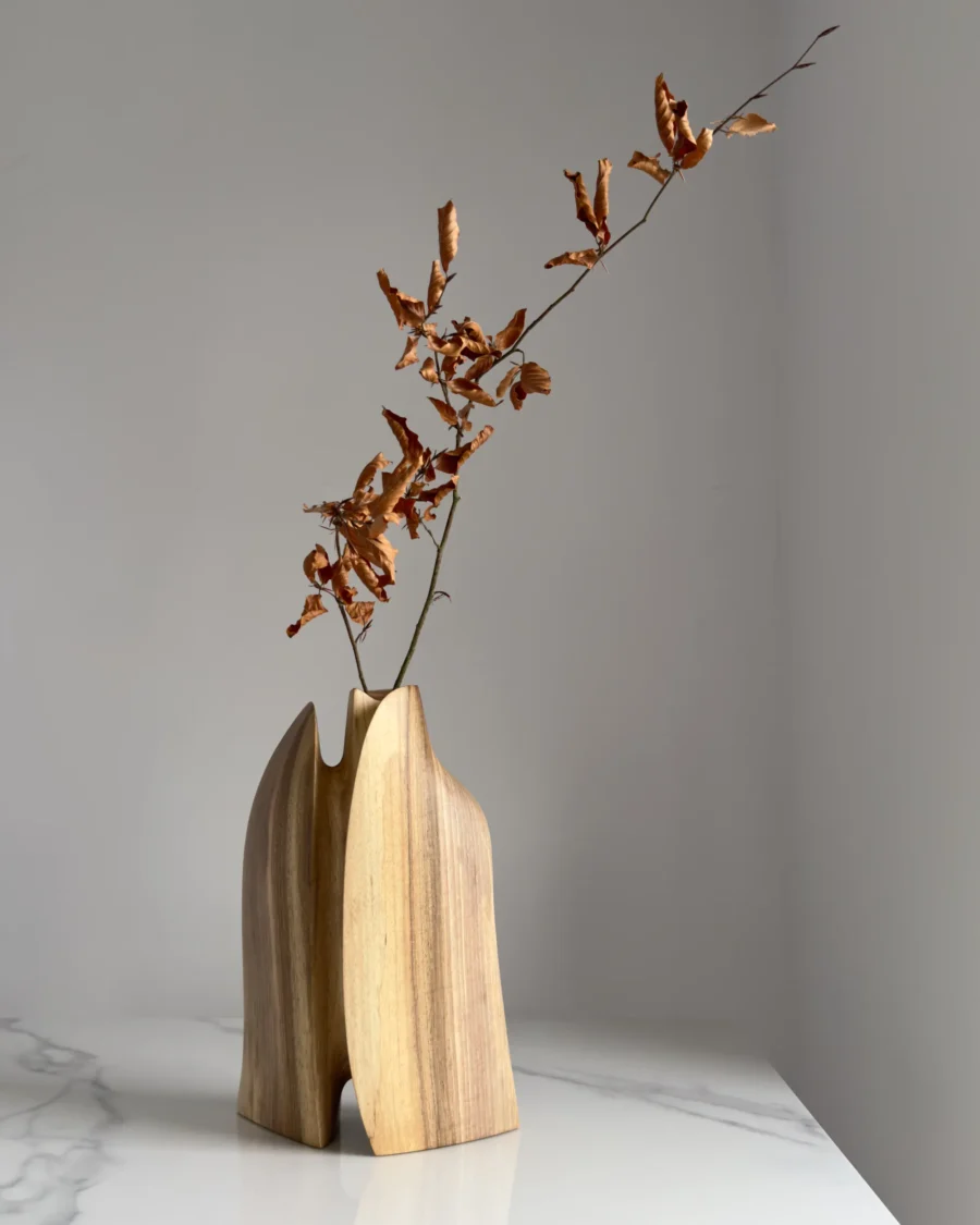 Twin Presence sculptural walnut vase displayed with a single natural branch in its removable glass insert.