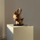 aperture-abstract-walnut-wood-sculpture-view Aperture abstract walnut wood sculpture on black granite base in warm natural light