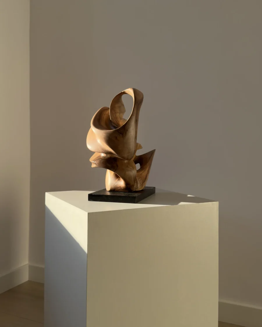 aperture-abstract-walnut-wood-sculpture-view Aperture abstract walnut wood sculpture on black granite base in warm natural light