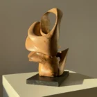 aperture-walnut-sculpture-changing-perspective Aperture abstract walnut wood sculpture on black granite base in warm natural light