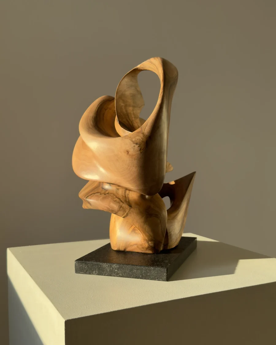 aperture-walnut-sculpture-changing-perspective Aperture abstract walnut wood sculpture on black granite base in warm natural light