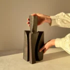 One-of-a-kind Counterpoise wooden vase held by the artist in warm sunlight, showing its handmade proportions and sculptural scale.