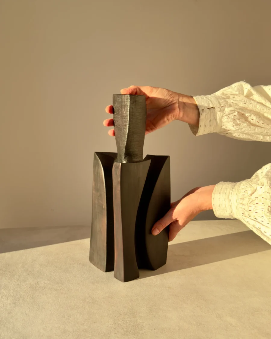 One-of-a-kind Counterpoise wooden vase held by the artist in warm sunlight, showing its handmade proportions and sculptural scale.
