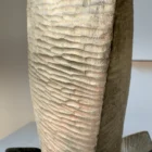 Macro detail of the hand-carved pear wood surface on Counterpoise, with irregular tool marks revealed by natural light.