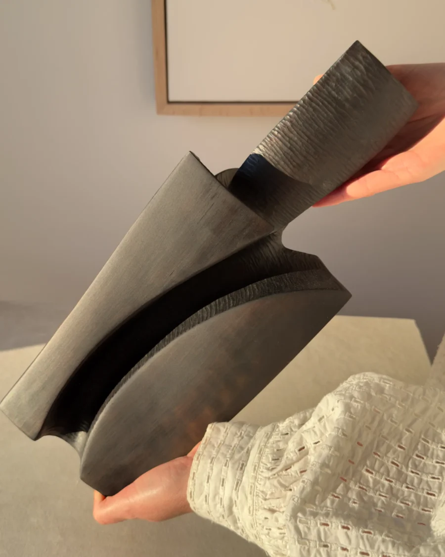 Close view of Counterpoise pear wood sculpture showing smooth curved planes, deep carved channels and visible hand-tool texture.
