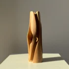 Side view of the Hidden Heart cherry wood vase showing the small opening that reveals its hidden inner chamber.