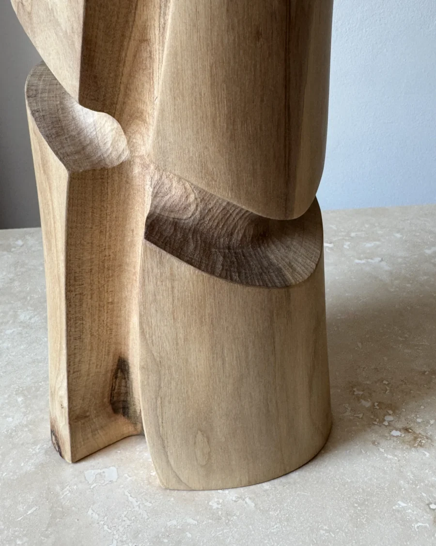 Detail of the hand-carved surfaces and natural walnut grain on the Knot wooden vase.