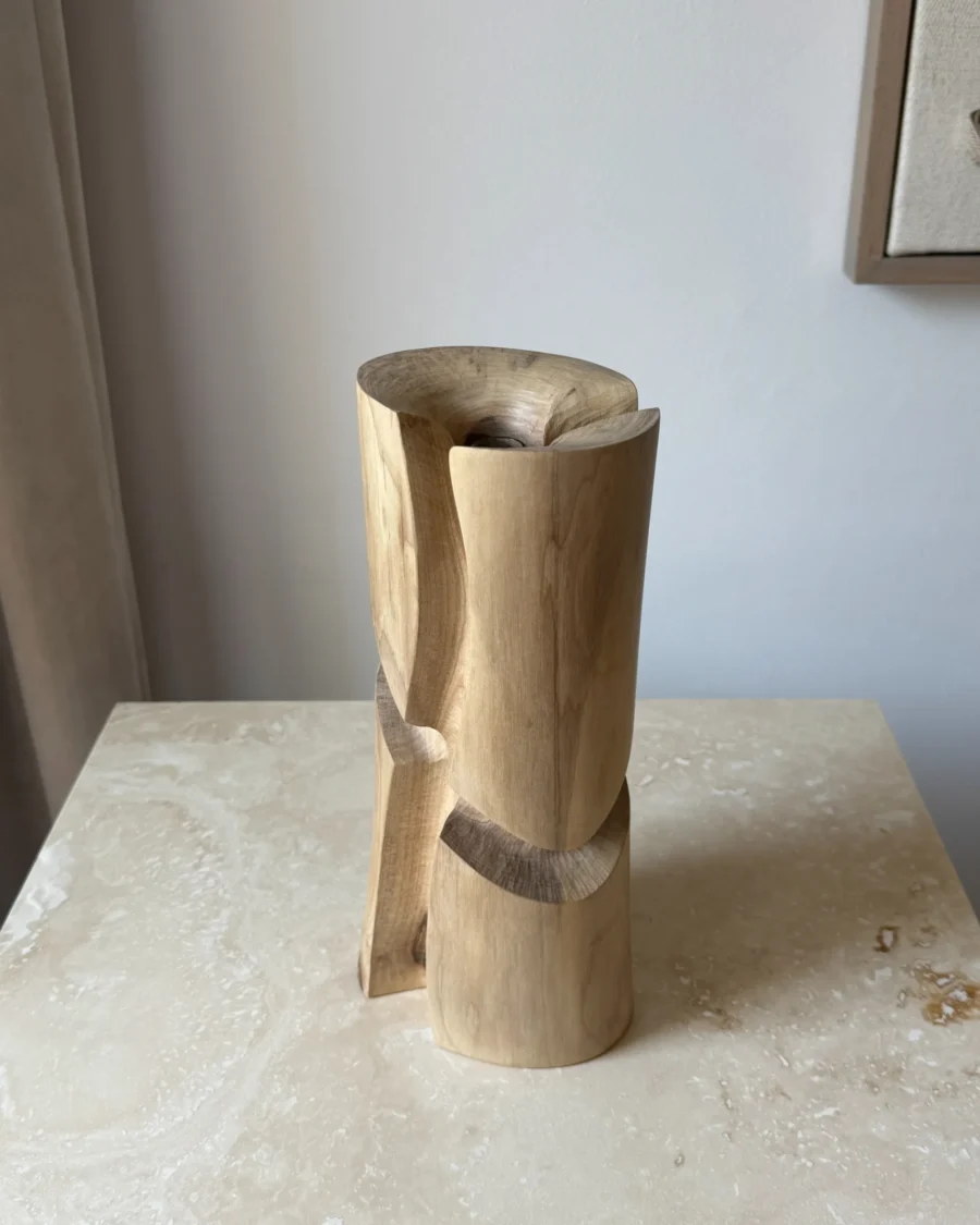 Three-quarter view of Knot sculptural walnut wood vase showing its organic carved geometry.