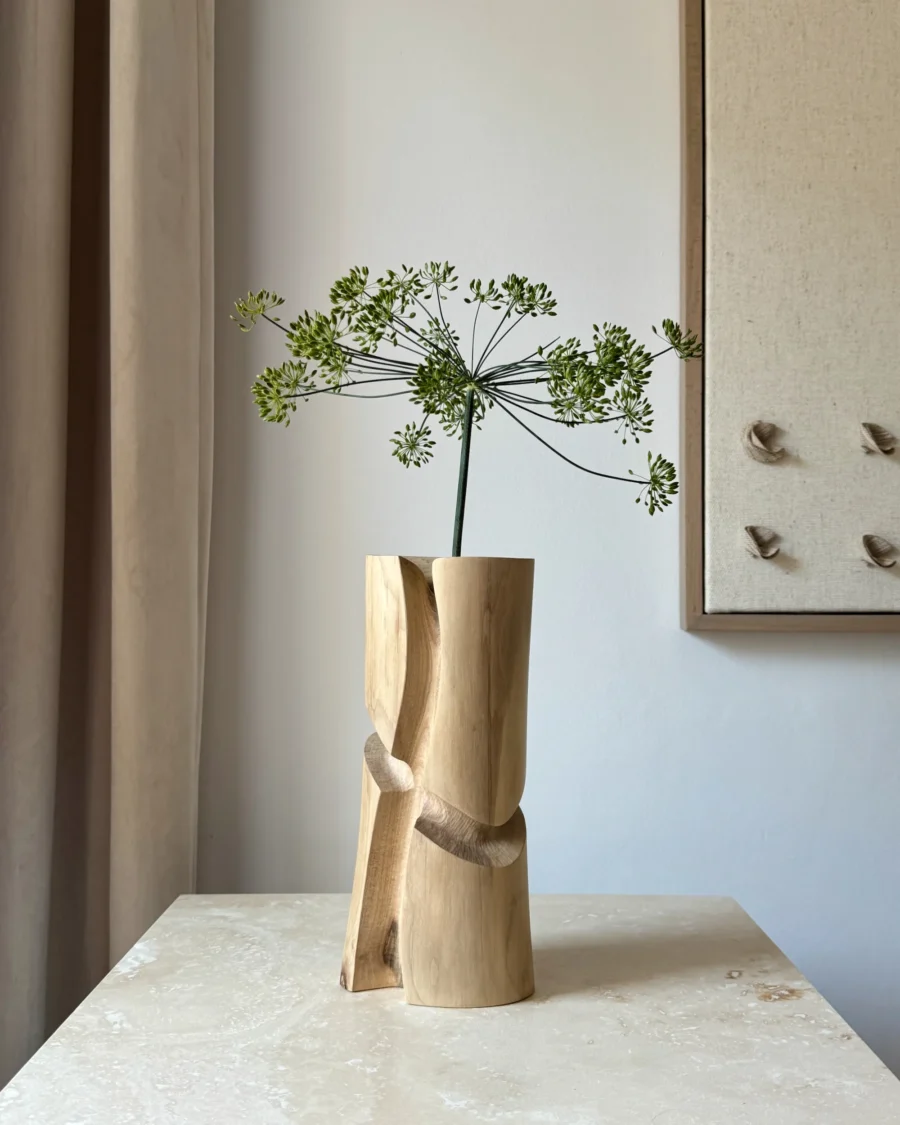 Knot one-of-a-kind hand-carved walnut wood vase displayed with a single dill flower in natural light.