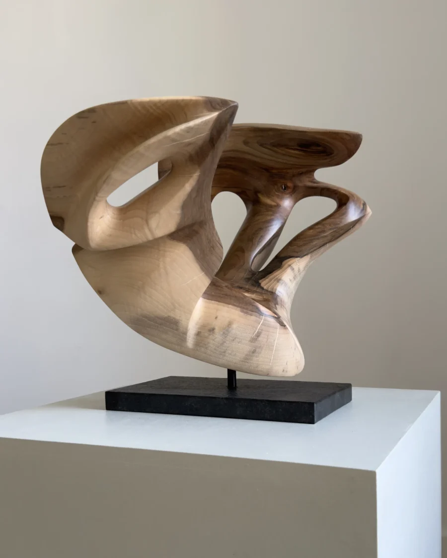 becoming-abstract-walnut-wood-sculpture Becoming, one-of-a-kind abstract walnut wood sculpture with an open asymmetrical form, hand-carved from solid wood and displayed on a black granite base.