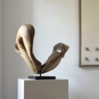 becoming-asymmetrical-walnut-sculpture-rear-view Becoming displayed on a pedestal beside a neutral textile artwork, showing how the asymmetrical walnut sculpture changes from a side angle.