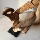 becoming-hand-carved-sculpture-top-view View from above of Becoming held by the artist, revealing the depth between its carved walnut forms and the sculpture’s complex three-dimensional structure.