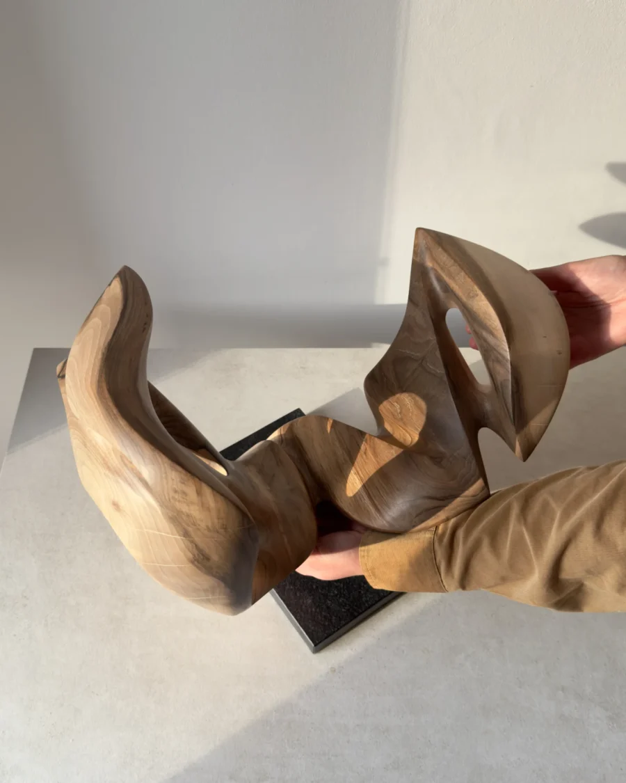 becoming-solid-walnut-sculpture-handmade-scale Full view of Becoming in natural light, showing its open asymmetrical silhouette, contrasting walnut tones and black granite base.