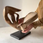 becoming-solid-walnut-sculpture-scale Becoming supported by the artist’s hands, showing its substantial solid walnut body, carved curves, openings and black granite base.