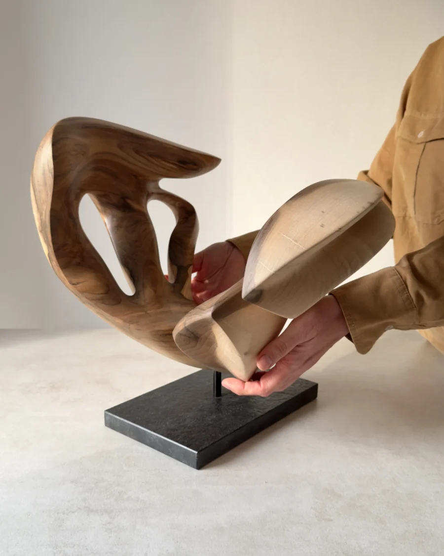 becoming-solid-walnut-sculpture-scale Becoming supported by the artist’s hands, showing its substantial solid walnut body, carved curves, openings and black granite base.