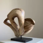becoming-walnut-sculpture-changing-perspective Side view of Becoming in natural light, where one pale carved form crosses in front of the darker open structure behind it.