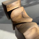 Close-up of Dynamic Contours showing smooth hand-carved surfaces, curved transitions and dark natural grain in solid walnut.