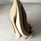 Angled view of Flowing Unity showing layered organic forms carved from a single piece of walnut