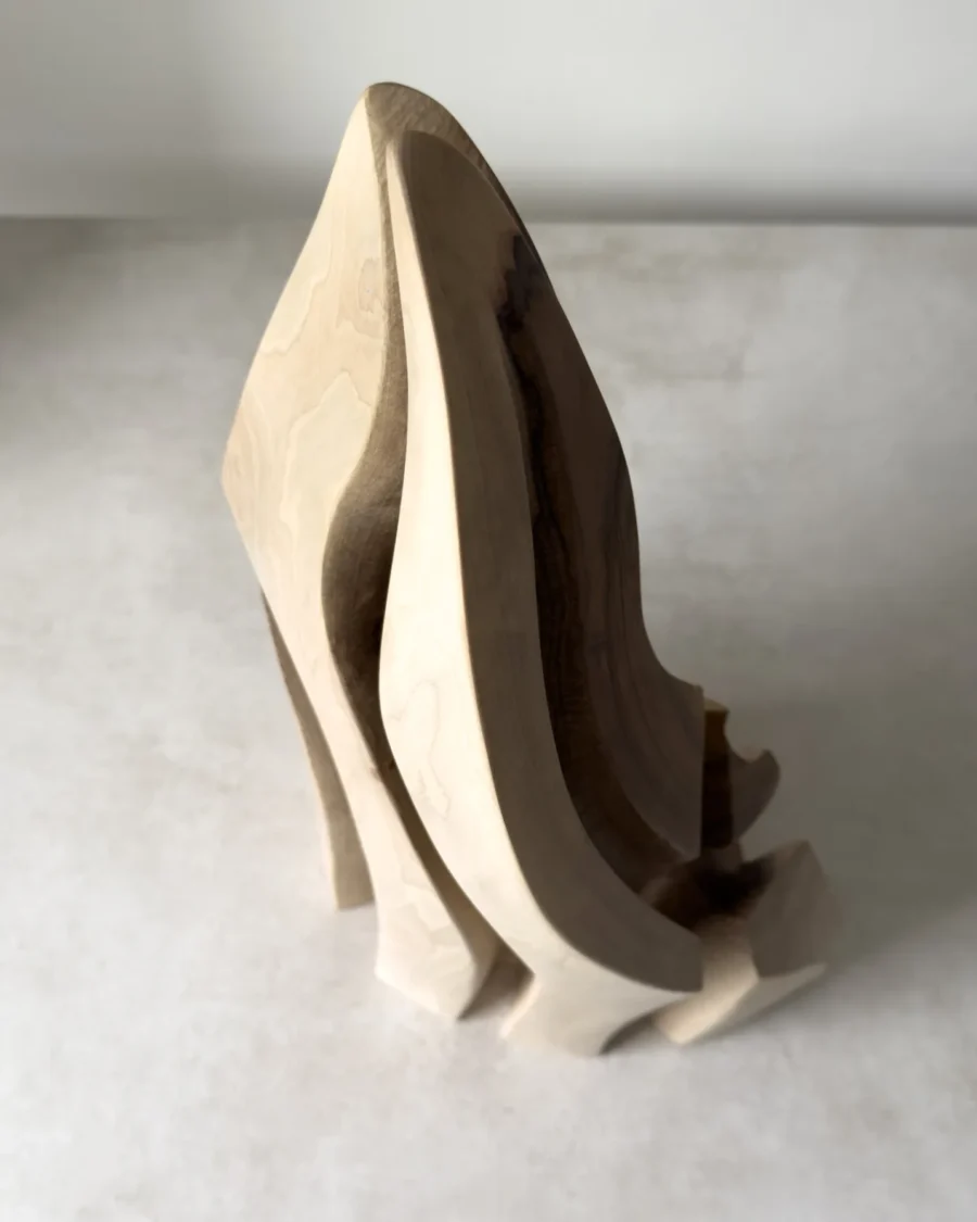 Angled view of Flowing Unity showing layered organic forms carved from a single piece of walnut