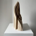 Side view of Flowing Unity showing the slender profile of the hand-carved walnut sculpture