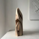 Side view of Flowing Unity showing the layered hand-carved forms and natural walnut grain