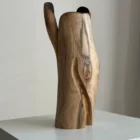 Side view of Hollow contemporary walnut sculpture showing its tall asymmetric silhouette and narrow dark opening.