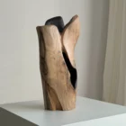 Angled view of Hollow walnut vase revealing the contrast between smooth natural wood surfaces and its dark carved hollow.
