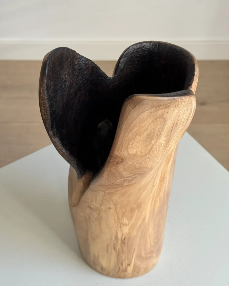 Close view of Hollow walnut sculptural vase showing the deep charred interior, hand-carved texture and smooth natural wood exterior.