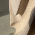 Close-up of Hush showing the hand-carved texture of apple wood, with visible tool marks, softly white-waxed recesses and smooth surfaces revealed by natural light.