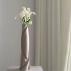 Side profile of the Hush sculptural vase with a sweeping carved edge and softly muted apple wood grain.