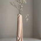 Hush sculptural wood vase styled with a delicate branch against a quiet light interior, highlighting its Scandinavian character.