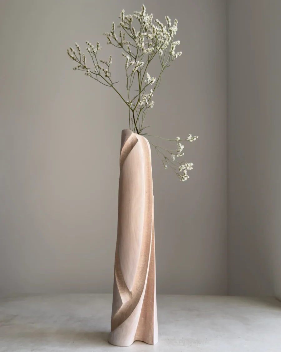 Hush sculptural wood vase styled with a delicate branch against a quiet light interior, highlighting its Scandinavian character.
