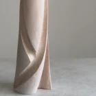 Close-up of the lower part of Hush, showing the contrast between smooth white-waxed apple wood and the hand-carved textured recesses following the flowing form.