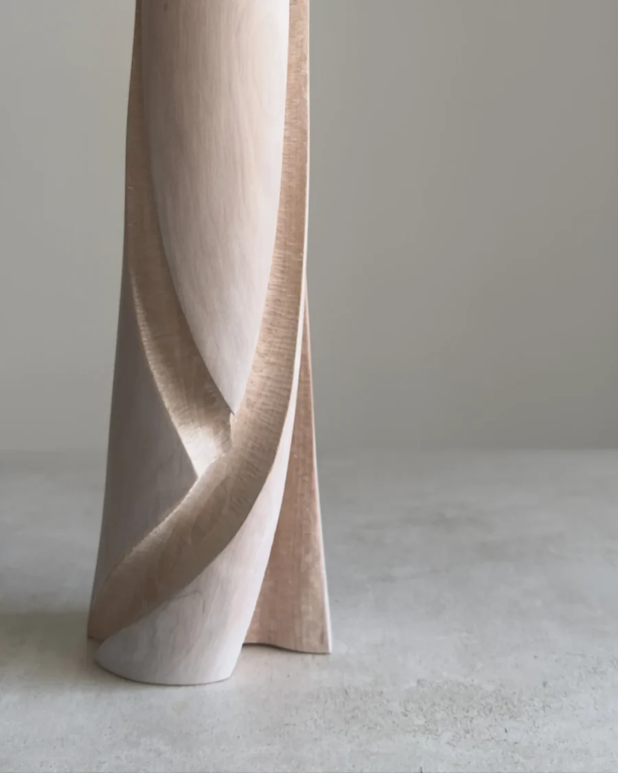 Close-up of the lower part of Hush, showing the contrast between smooth white-waxed apple wood and the hand-carved textured recesses following the flowing form.