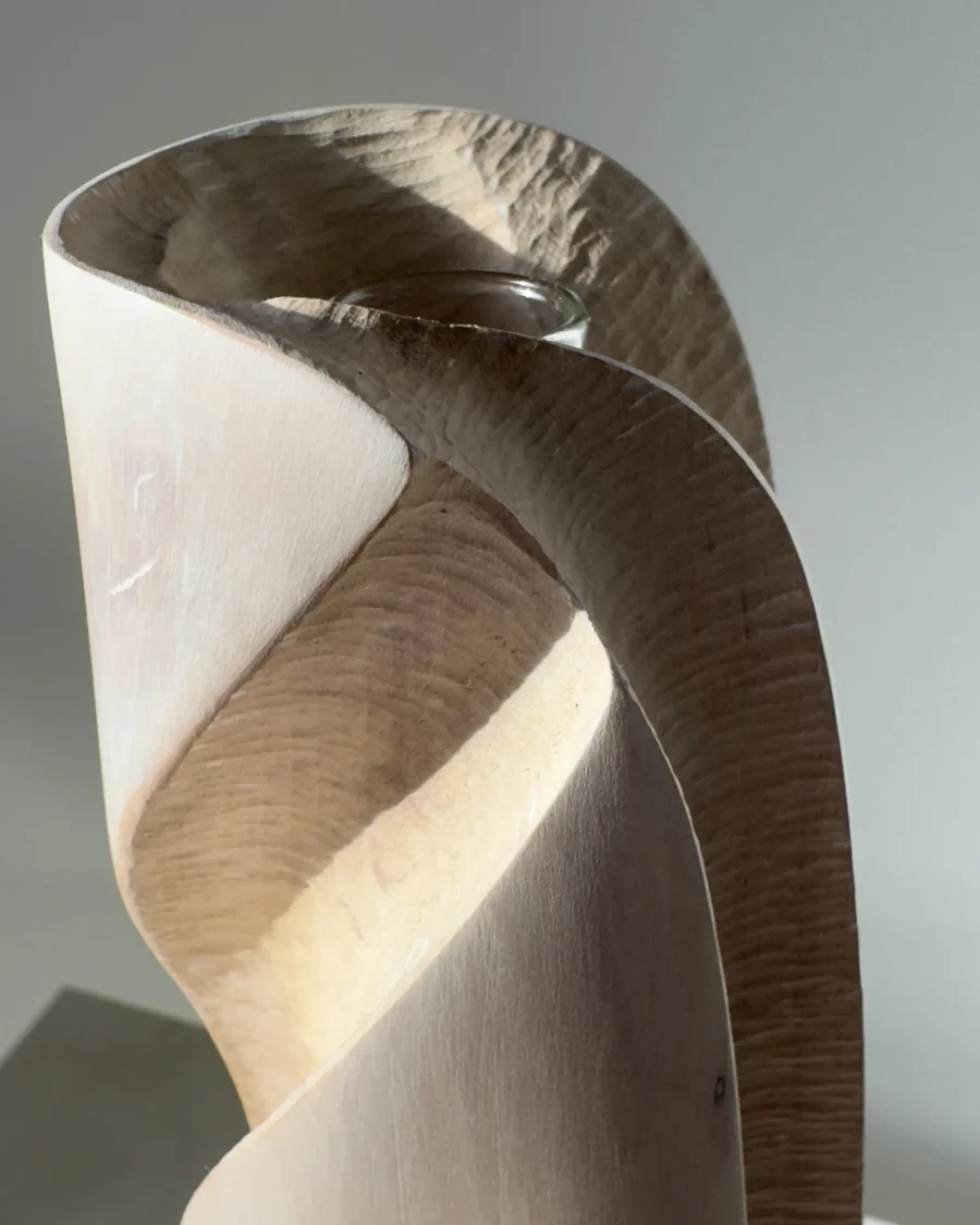 Detail of Hush showing the removable glass tube, fresh lily and hand-carved texture inside the pale recessed surface.