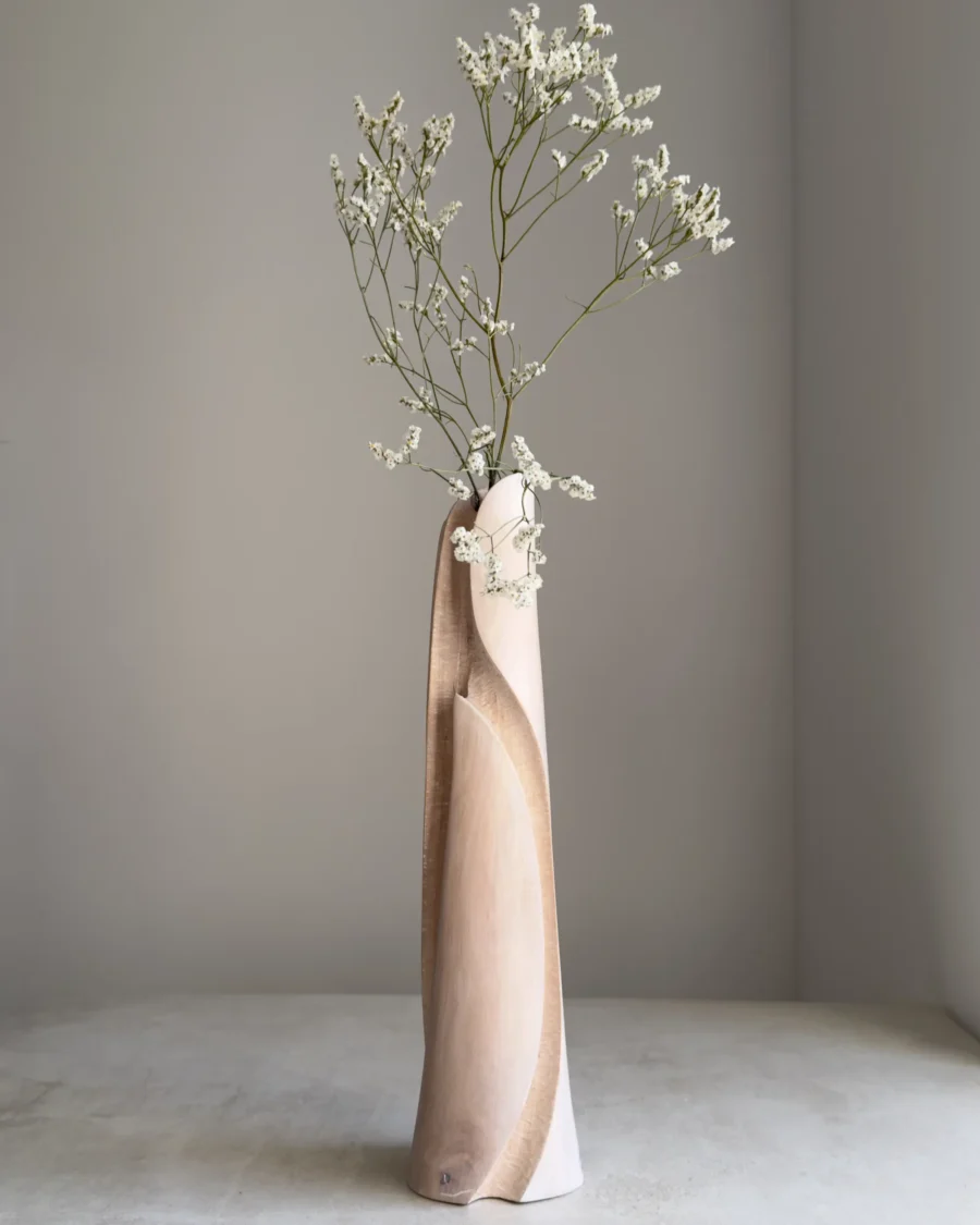 Hush hand-carved wood vase holding a delicate white flowering branch in its removable glass tube.