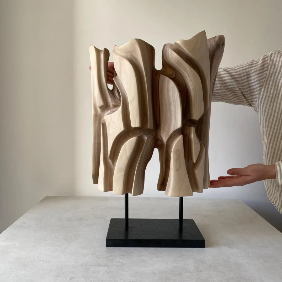 Interstice hand-carved abstract wood sculpture with flowing openings and black granite base, front view