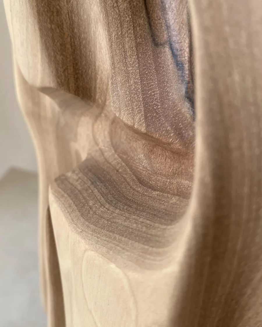 Close-up of the hand-carved surface and natural grain of Interstice wood sculpture