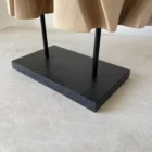 Detail of the black granite base and metal supports beneath Interstice wood sculpture