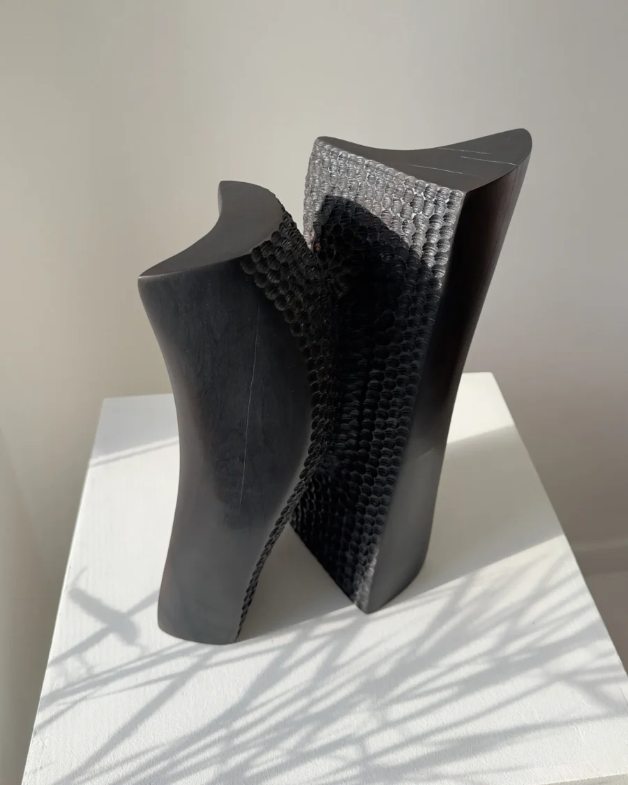 Pendere abstract black wood sculpture in its alternate stable position, showing how the form shifts from vertical balance into movement.